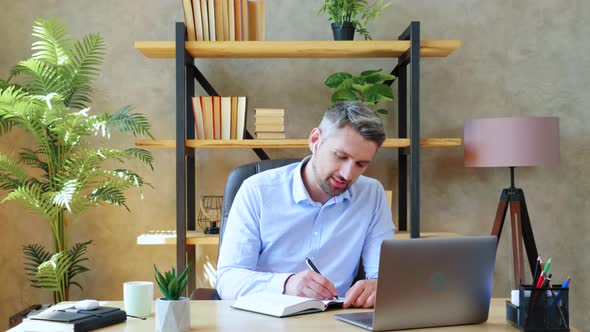 Smiling man at home office study remote online video call conference with teacher