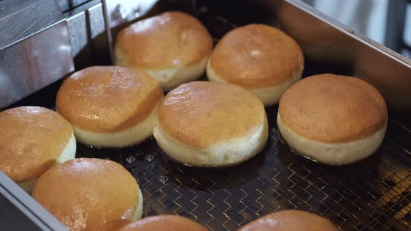 The Crumby Bases for Donuts Are Being Fried in a Fryer.