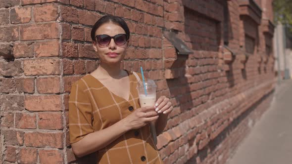 Woman Drinking Iced Coffee Outdoors