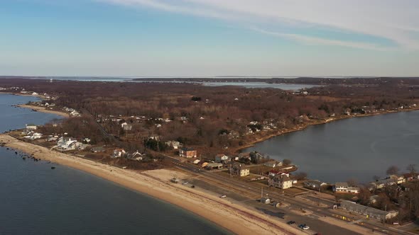 a high angle view over the calm waters at an empty beach, on a day with blue skies. The drone camera