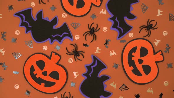 composition of Halloween decorations,pumpkins, bats, spiders,cobwebs rotate on an orange background.