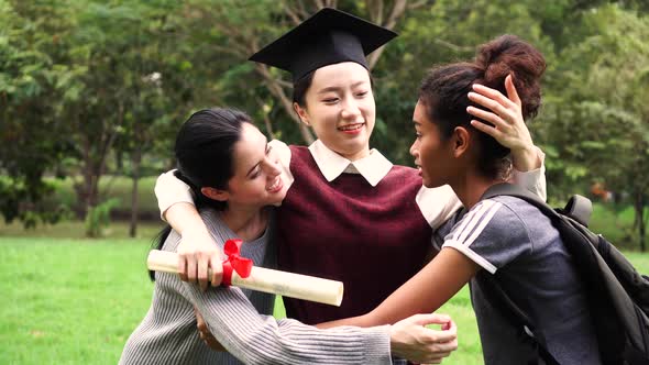 Young Female Graduate Embracing Her Friends at Graduation Ceremony