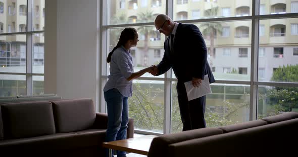 Woman Is Meeting Man in Hall of Office Building, They Are Shake Hands, Sitting on Couches