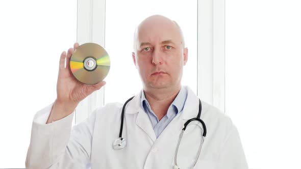 Bald Doctor Showing CD Disk Front Camera on White Window Background