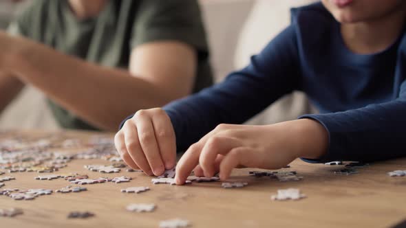 Close up video of father and son solving jigsaw puzzle. Shot with RED helium camera in 8K.