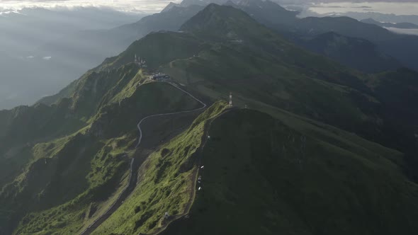 Aerial Top View Mountain Ridge Panorama Flight Through the Clouds at Sunrise