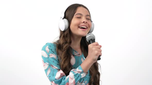 Happy Child Singer Listen Music in Headphones and Sing Karaoke Song in Microphone Music