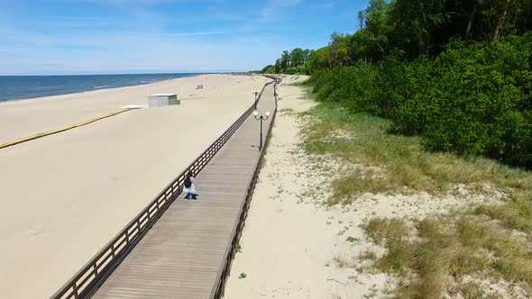 Aerial view of the long wooden promenade on a beach of Yantarny resort town, Russia