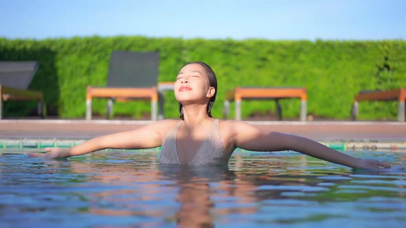 Young asian woman enjoy around outdoor swimming pool for leisure