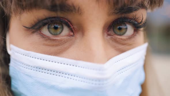 Macro Sore Eye of VERY TIRED Female Doctor in Medical Mask Looking at you