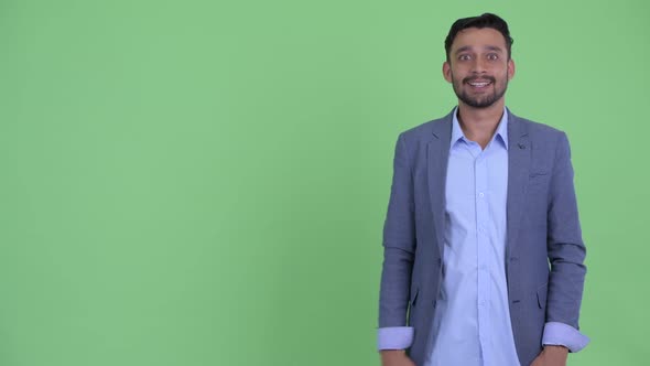 Happy Young Bearded Persian Businessman Snapping Fingers and Giving Thumbs Up