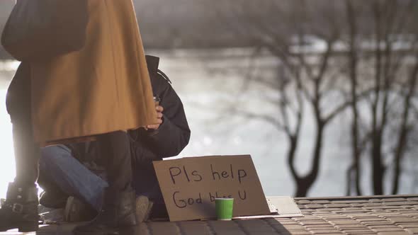 Female Sharing Hot Coffee with Homeless Man