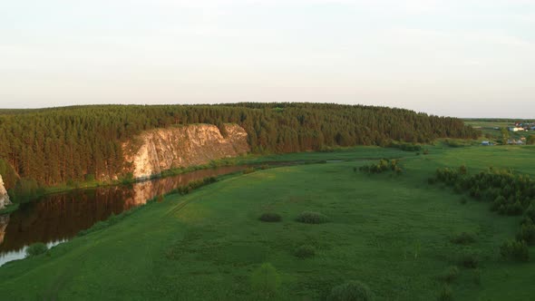 Aerial View of the River with a Rock and Forest on the Banks