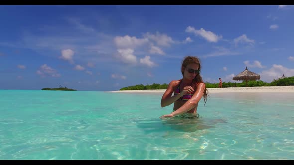 Ladies together best friends on tranquil island beach wildlife by blue sea with white sandy backgrou