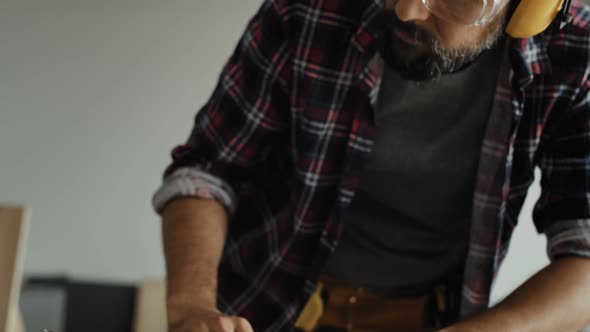 Woodworker using table saw to cut piece of wood. Shot with RED helium camera in 8K