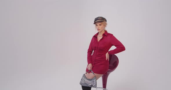 Young Girl Model Posing In A Red Dress In The Studio For A Photographer