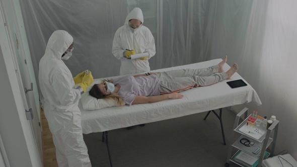 Doctor taking temperature to patient in field hospital