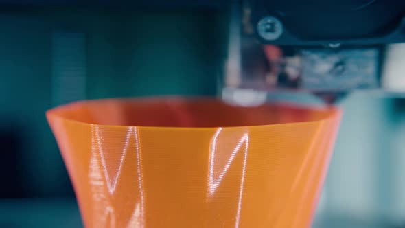 Fast Motion of Orange Plastic Layers Getting Made By 3Dprinter