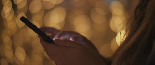 Close up of a young woman's hands scrolling over social media on her phone