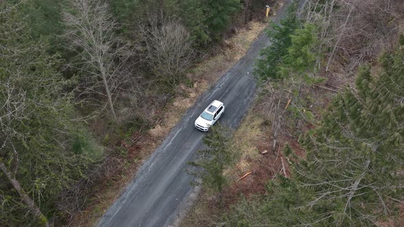 White suv car driving along tortuous mountain road. Aerial top-down view