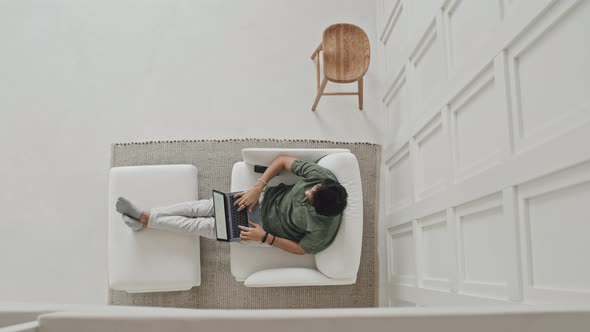 Man Using Laptop Computer in Armchair