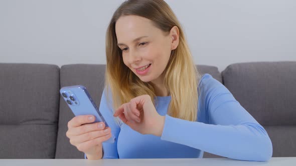 Cheerful blonde female using modern smartphone for communication online on social media app in 4k
