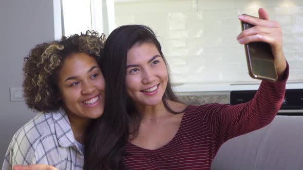 Asian and African American Black Woman Taking Selfie Using Smartphone