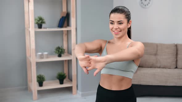 Happy Brunette Woman Warming Up Hands Enjoying Morning Physical Activity at Home Exercising Workout