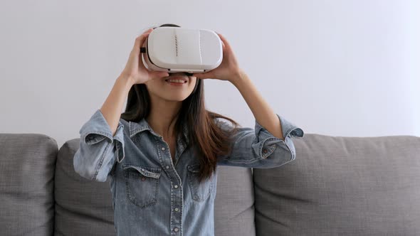 Woman looking though virtual reality device at home 