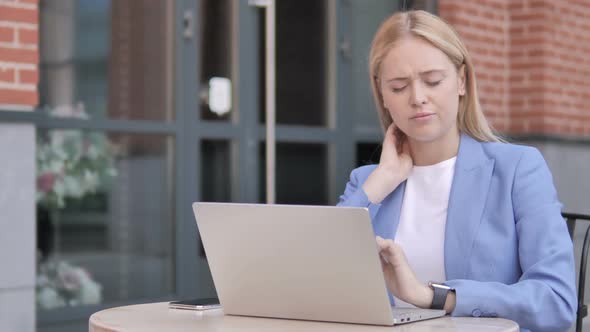 Young Businesswoman with Neck Pain Using Laptop Outdoor