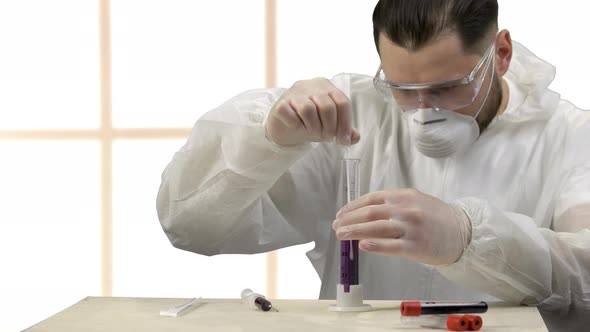 Medical Scientist Stirring Up Purple Liquid in a Test Tube