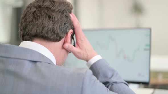 Businessman Celebrating While Reading Charts on Desktop