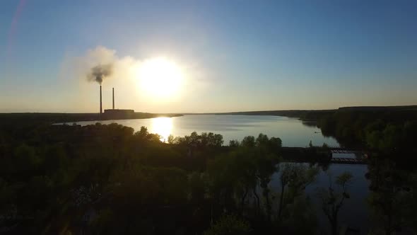 Smoking factory at sunset. Industrial factory smoke from smokestacks over sunset