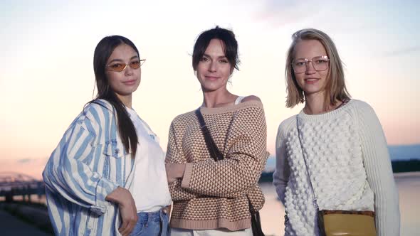 Three Attractive Female Friends Looking To Camera Posing.