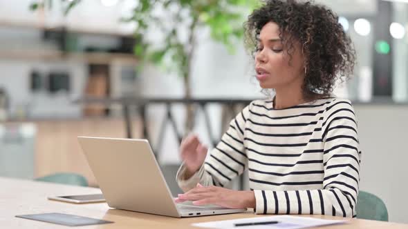 Sick African Woman with Laptop Coughing in Office