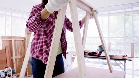 Stylish craftswoman working in carpentry. Woodwork and furniture making concept.