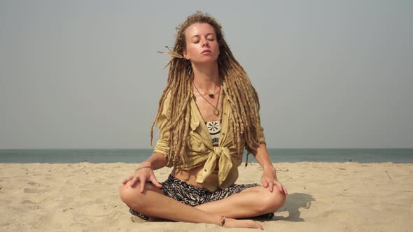 Hippie Woman in Lotus Position on the Sea Coast