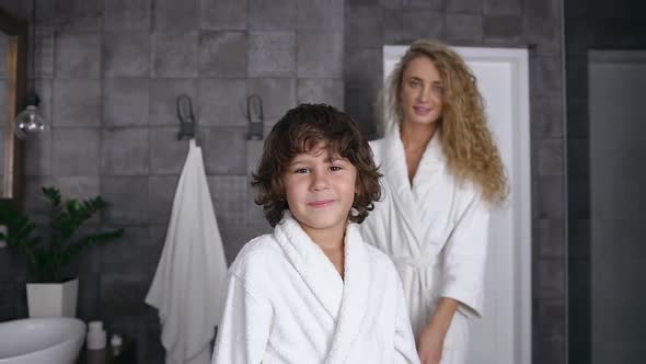  Boy in a White Coat who is Standing in the Bathroom while His Beloved Mother Comes to Him