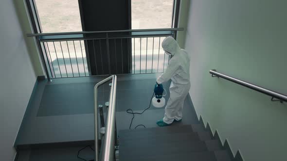 Top view of person in protective suit disinfecting the staircase. Shot with RED helium camera in 8K.