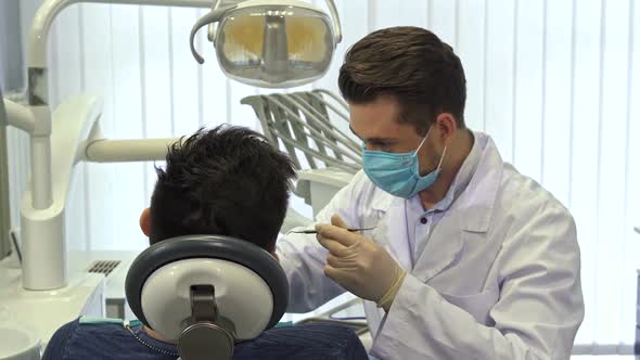 Dentist Examining Client's Teeth at the Office