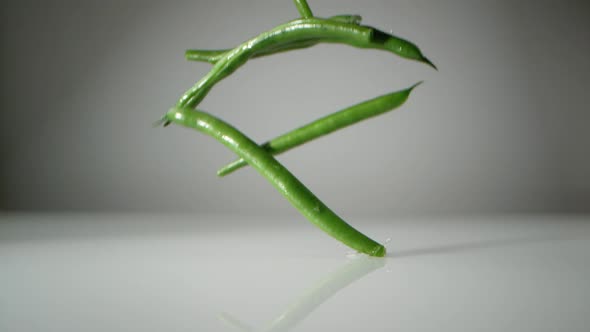 Green beans on water surface. Slow Motion.