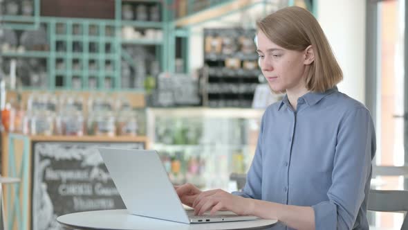 Young Woman Showing Thumbs Down While Using Laptop