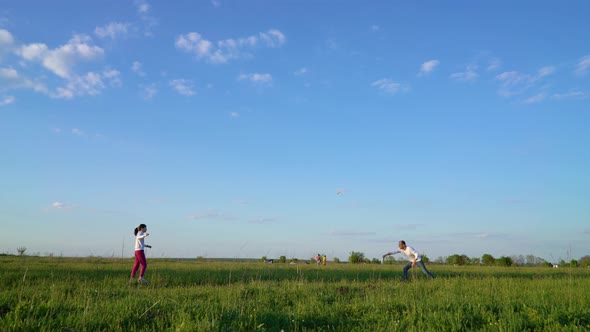 Father and daughter playing frisbee on green field