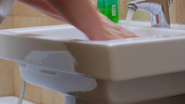 Caucasian Woman Washing Hands Under the Faucet