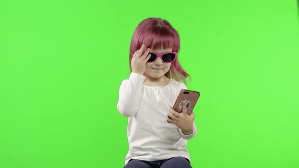 Girl Using Smartphone. Child Emotionally Talking on Mobile Phone, Take Selfie
