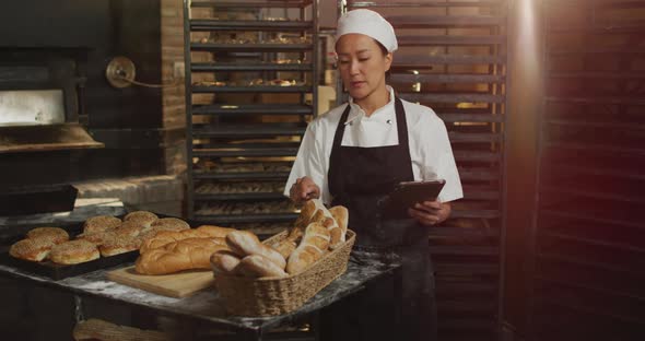 Animation of asina female worker using tablet and counting breads