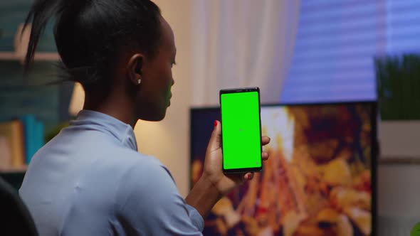 Lady Looking at Green Screen Smartphone While Relaxing at Home