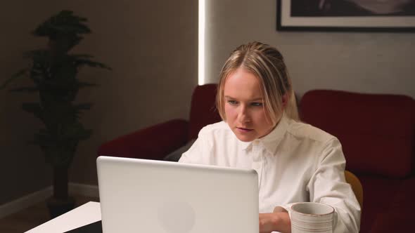 Pretty Young Happy Woman Working on Laptop at Home Talking Phone