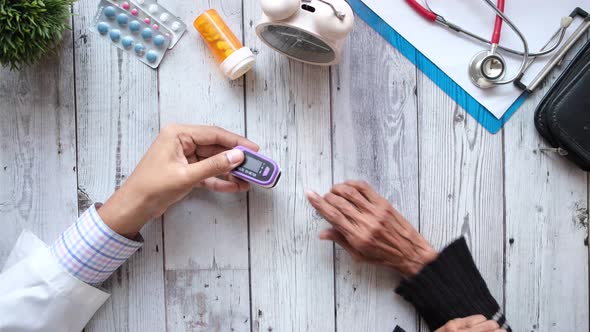 Doctor Helping Senior Patient Measuring Pulse Rate