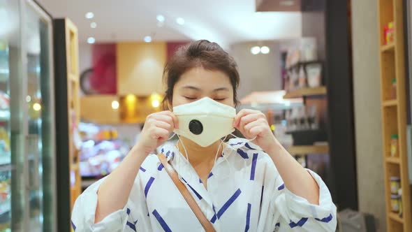 young asian female wearing protective face mask prevention in supermarket department store mall